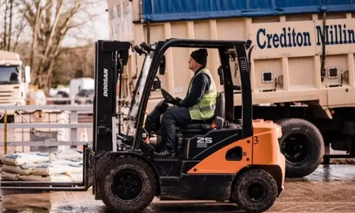 A forklift in front of a Crediton Milling Lorry